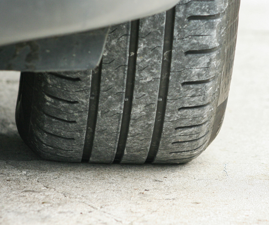 A tire on the pavement is facing straight on to show its tread wear.